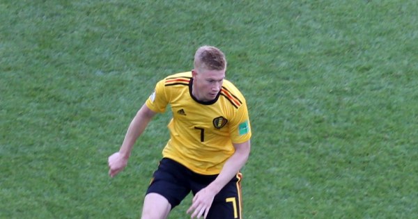 Focused midfielder passing ball with precise technique during game.