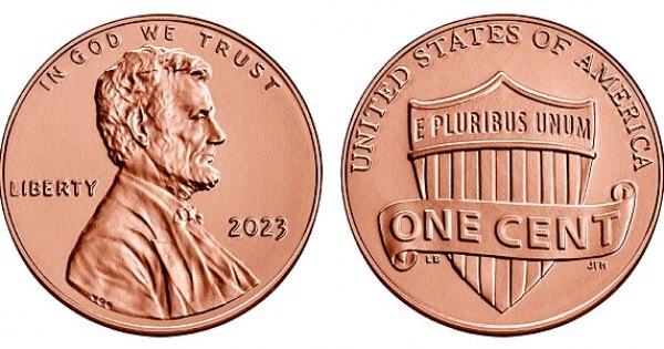 Shiny copper penny close-up on rustic wood surface.